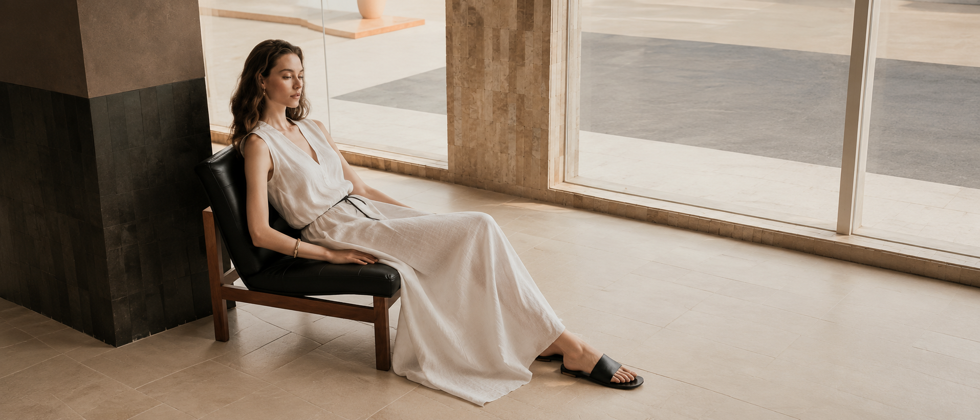 Woman wearing a flowing neutral dress in a modern interior